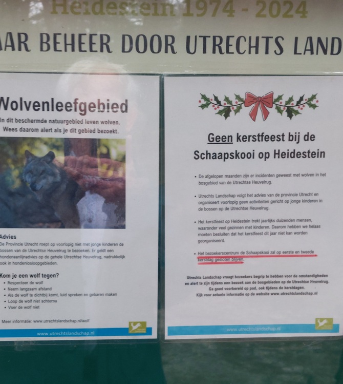 Informatiebord van het Utrechts Landschap waarop het wolvengebied staat aangegeven en de aankondiging staat dat de kerststal in de schaapskooi niet door gaat