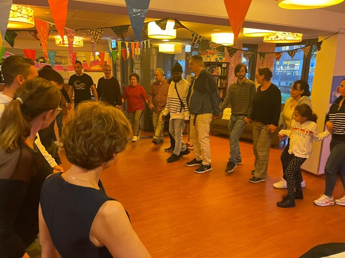 Deelnemers aan de Buddy to Buddy matchingsavond Zeist dansen in een grote kring