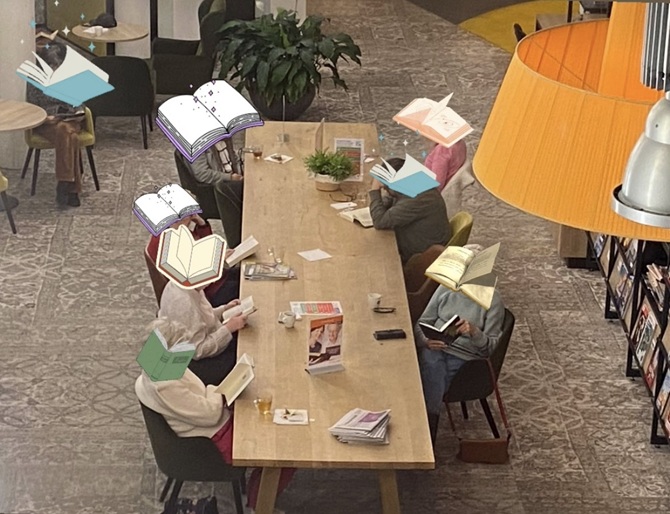 Deelnemers aan de Silent Reading Club Zeist lezen in de bibliotheek in hun boek