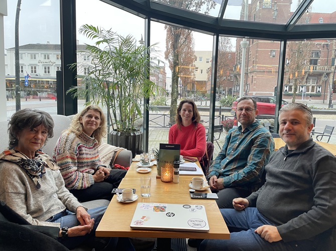 De vijf deelnemers aan het gesprek zitten rond de tafel bij het raam van Figi in Zeist