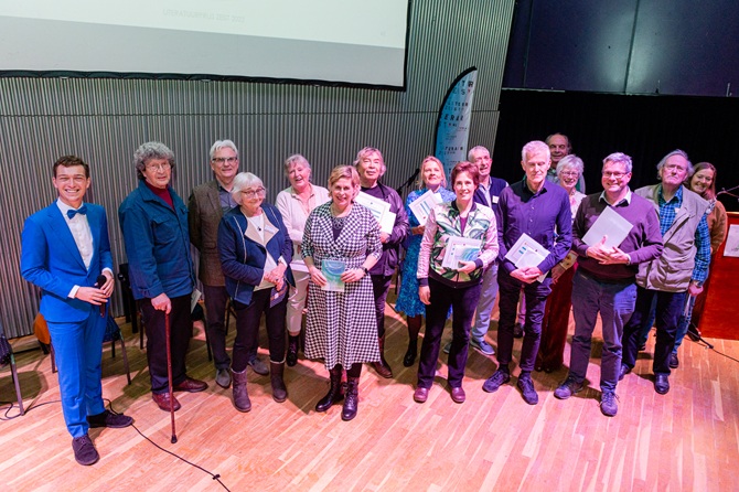 Podium vol mensen, de winnaars van de Literatuurprijs Zeist 2022, presentator Daan Warnas en mensen van het organiserende Literair Zeist