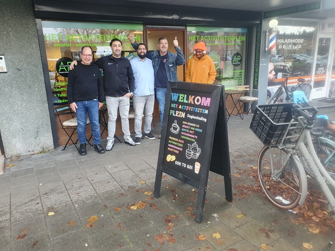 Initiatiefnemers en eerste deelnemers staan voor de gevel van de nieuwe dagbestedingslocatie Activiteitenplein in Zeist