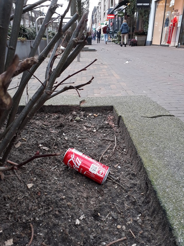 Een leeg blikje cola ligt onder een struik, op de Slotlaan in Zeist