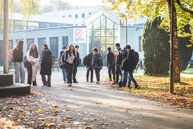 Een groep leerlingen loopt voor het gebouw van het OVMZ in Zeist