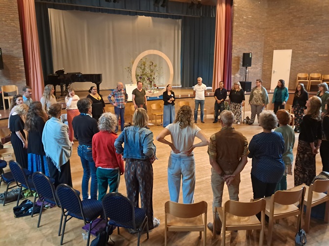 Een groep staat in een cirkel in het Zeister Centrum voor Zijnsoriëntatie in het Helicongebouw