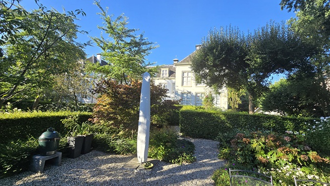 De tuin van huize Lommerlust in Zeist met groene heggen en een soort obelisk