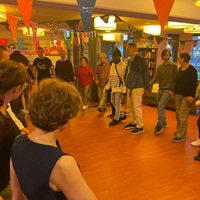 Deelnemers aan de matchingsavond van Buddy to Buddy Zeist dansen in een grote kring