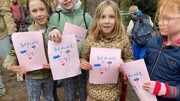 Vier leerlingen van Montessorischool Kerckebosch tonen een briefje waarop staat 'bedankt voor de fiets' tijdens de fietsopknapactie voor het AZC Kamp van Zeist