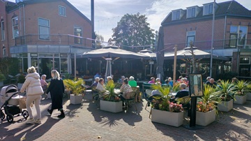 Het terras van café de Colonel in Zeist zit vol met mensen die genieten van het zonnetje