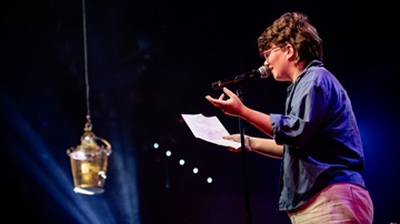 Een vrouw draagt haar gedicht voor tijdens Poetry Slam in Zeist