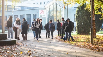 Een groep scholieren loopt voor de deur van het OVMZ in Zeist