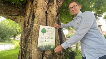 Een boom heeft een Tree Tag omgehangen gekregen met informatie over de duurzame prestaties van de boom