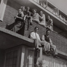 Oude zwartwitfoto van een familie uit Zeist die buiten op de rand van een woning zit